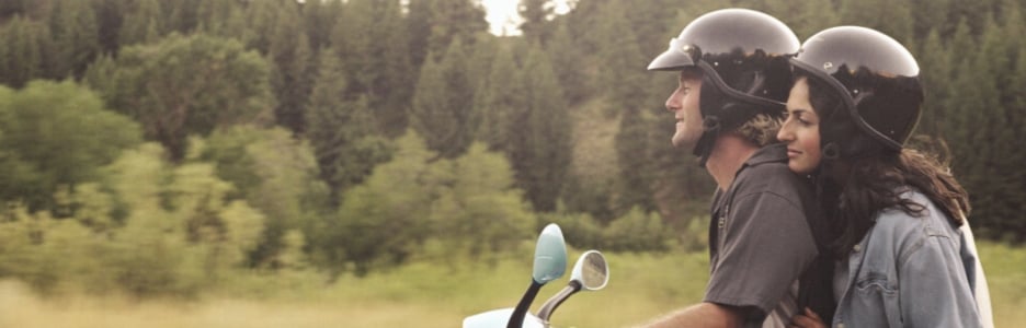 Imagen de una pareja montados en un ciclomotor