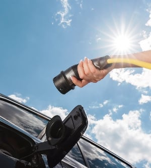 Imagen de una mujer cargando su coche eléctrico