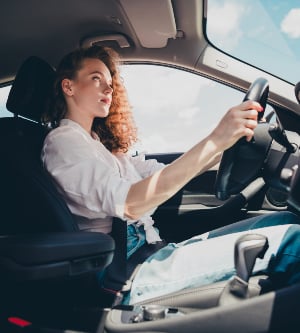 Imagen de una mujer joven conduciendo un automóvil en la ciudad retrato de una hermosa mujer en un automóvil mirando por la ventana y sonriendo