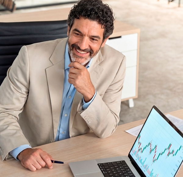 Imagen de un hombre sonriente mirando el historial de sus inversiones