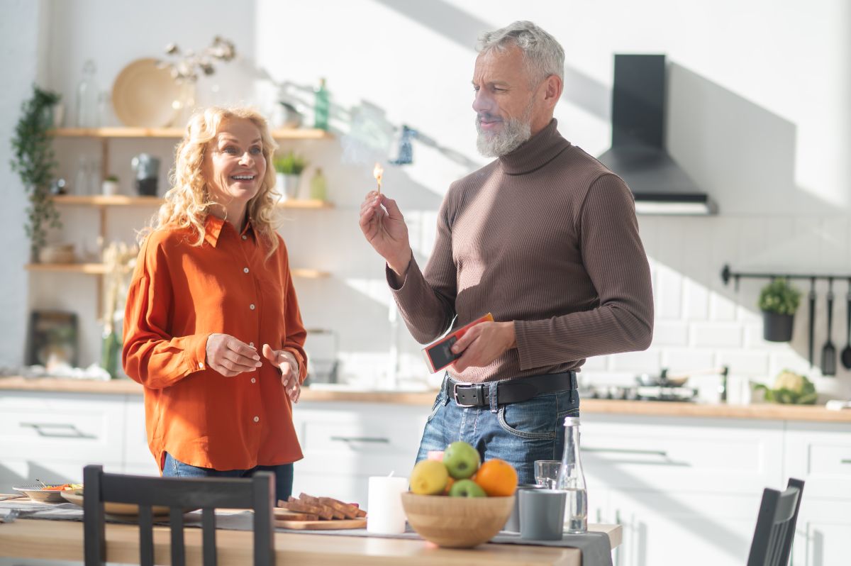 Image d'un homme qui souffle une allumette dans la cuisine