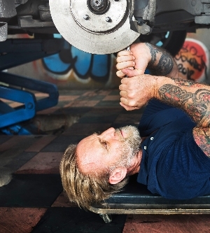 Imagen de un mecánico masculino arreglando un coche en el taller