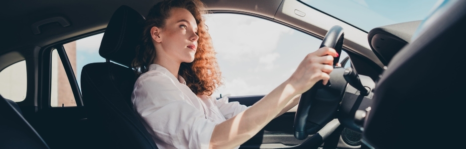 Imagen de una mujer joven conduciendo un automóvil en la ciudad retrato de una hermosa mujer en un automóvil mirando por la ventana y sonriendo