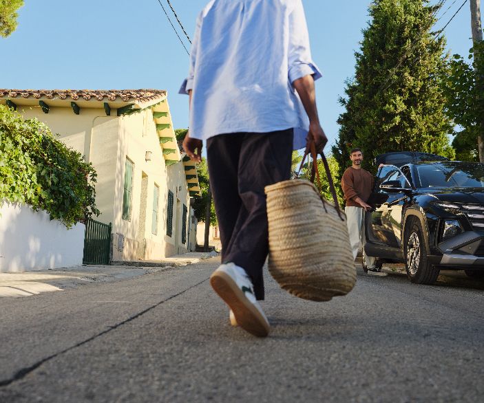 Imagen de una mujer entrando en su coche con su pareja esperando