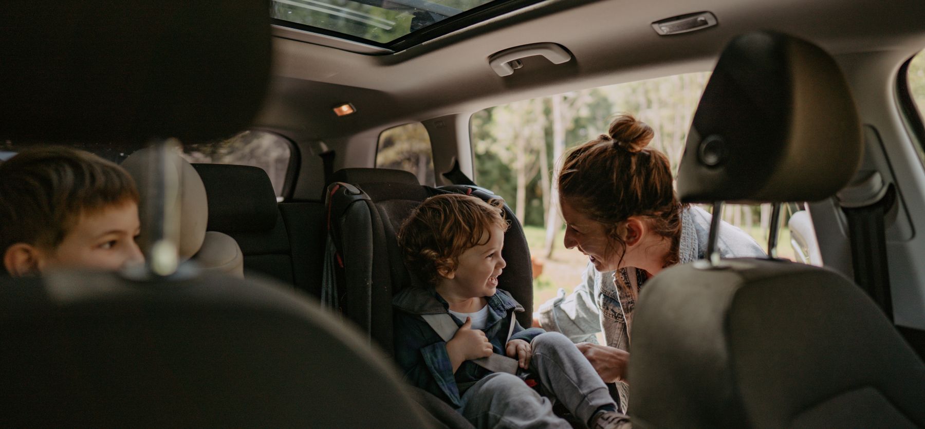 Imagen de una madre poniendo el asiento para su hijo en el coche