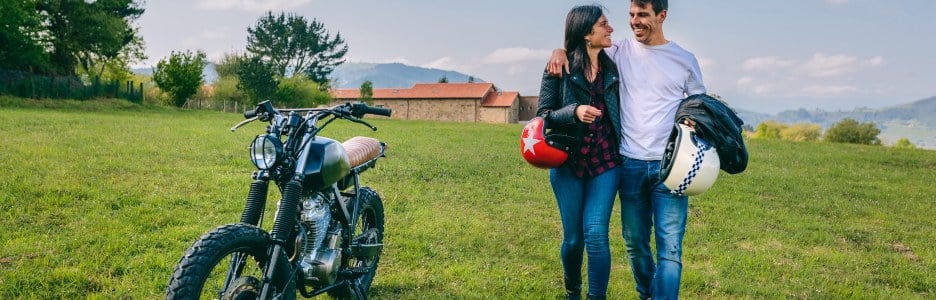 Imagen de una pareja paseando junto a su moto