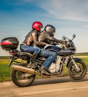 Imagen de dos personas en una motocicleta por la carretera