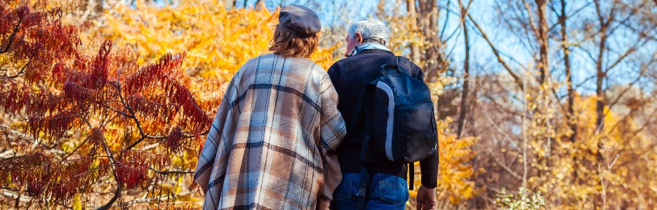 Imagen de una pareja mayor de la familia caminando en el parque de otoño. Hombre y mujer de mediana edad abrazándose y relajándose al aire libre.