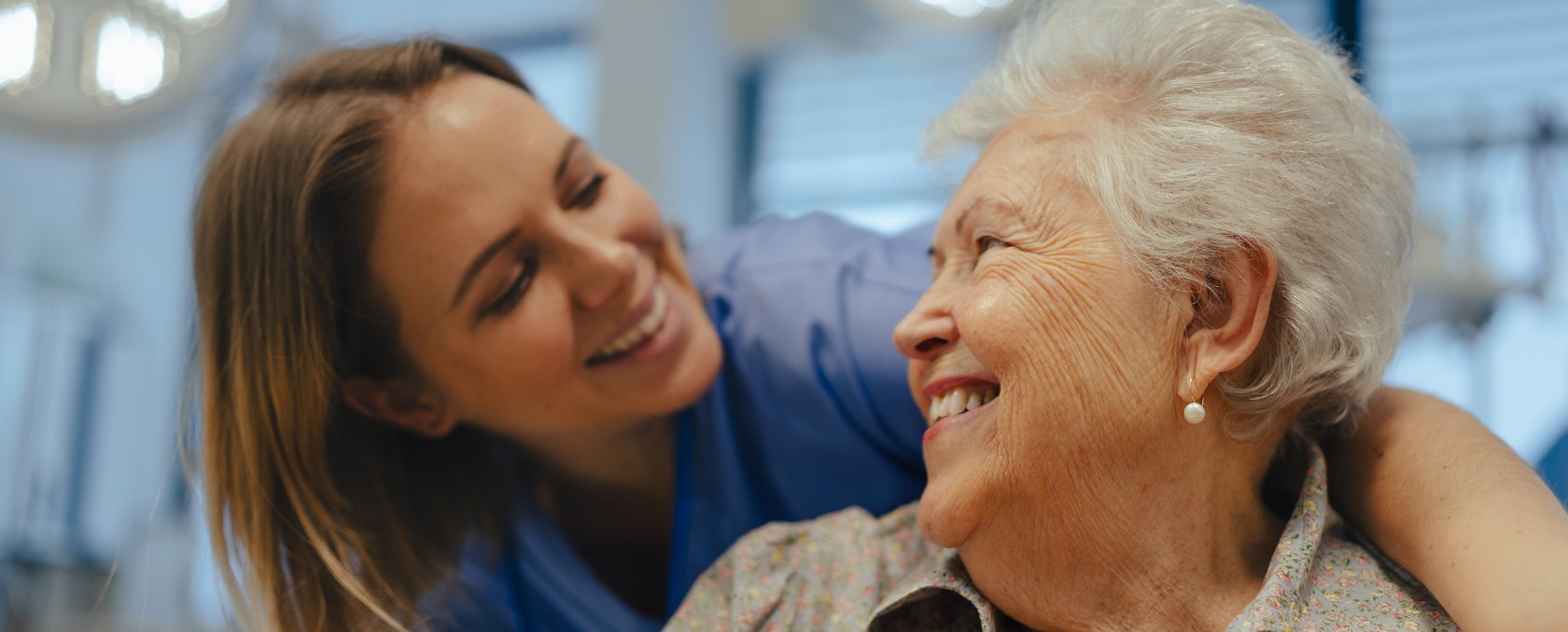 Imagen de retrato de enfermera y paciente mayor hablando en el pasillo del hospital. Apoyo emocional para mujer mayor