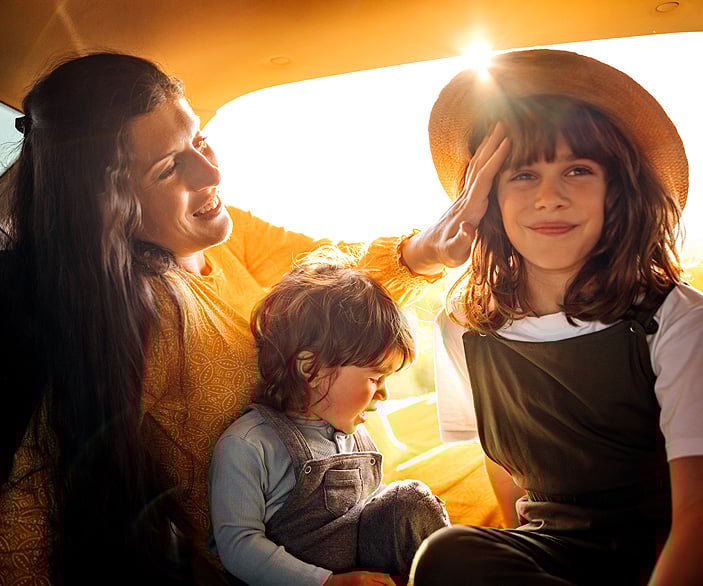 Imagen de una madre con sus dos hijas en el coche