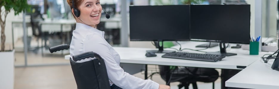 Imagen de una trabajadora en silla de rueda en su puesto de trabajo