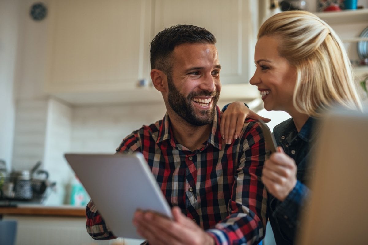 Imagen de una pareja felices con la compra de un tablet electrónico 