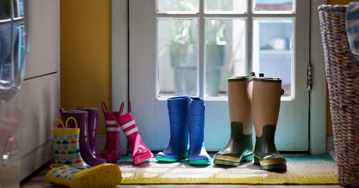 Imagen de botas colocadas dentro de la entrada de una casa