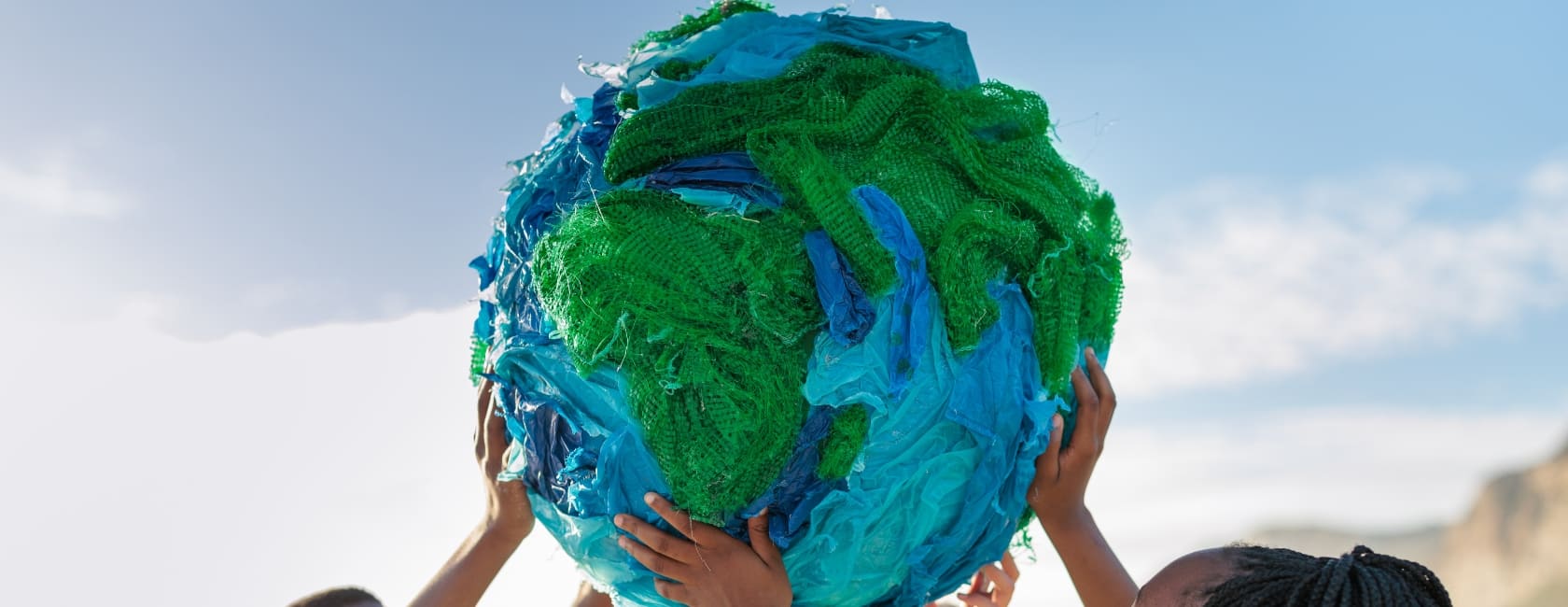  Imagen de un grupo de niños reciclando plástico del mar en forma de globo